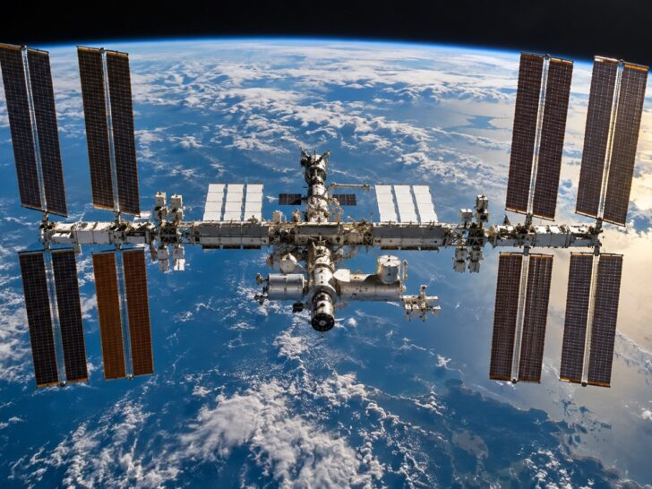 International Space Station orbiting above Earth with solar arrays visible.