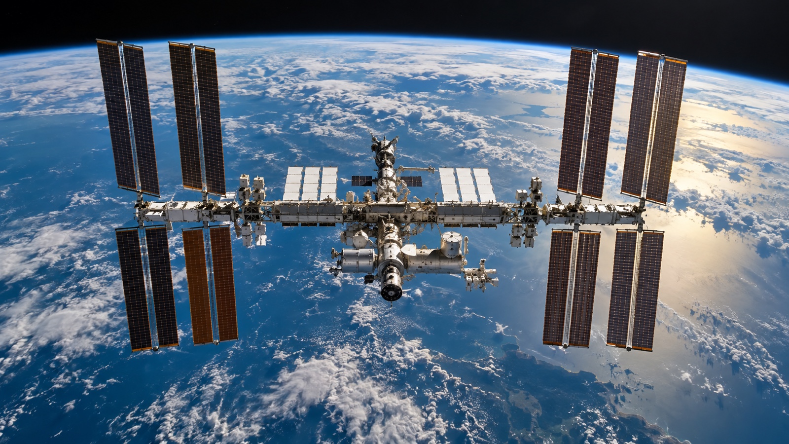 International Space Station orbiting above Earth with solar arrays visible.
