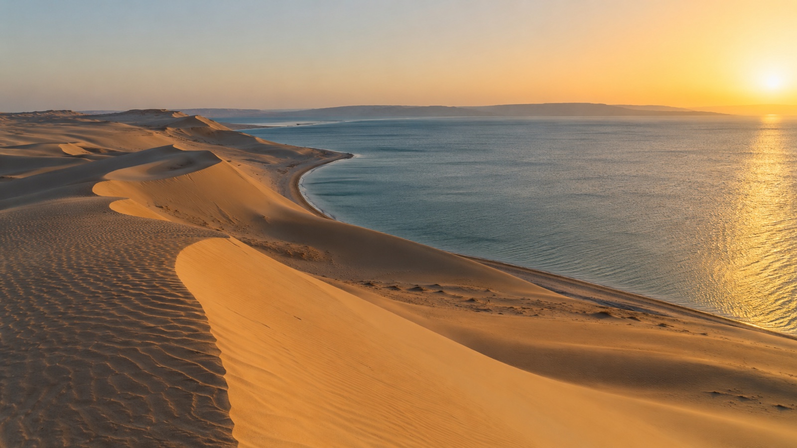 Golden Qatar desert dunes meeting the calm Inland Sea