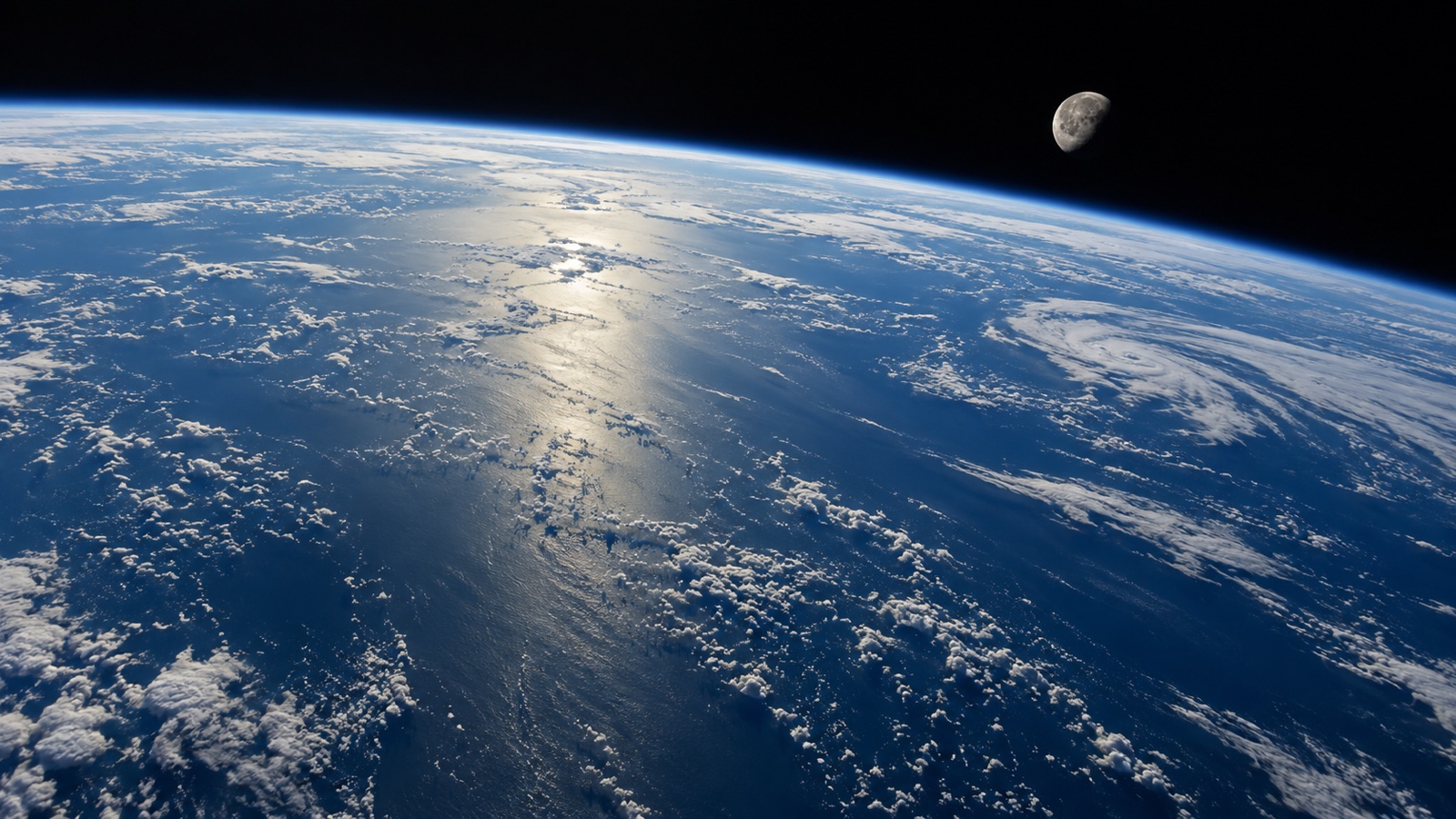 Moon beyond the curved ocean horizon of Earth as seen from low orbit.